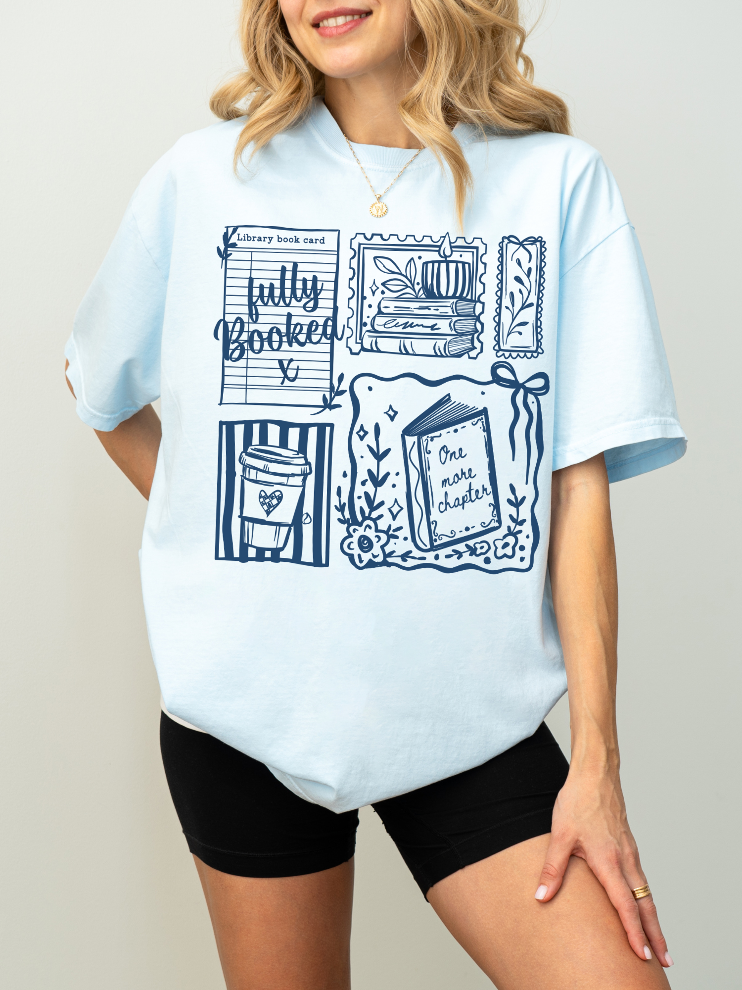 model wearing chambray fully booked book lover t shirt with illustrated books coffee and one more chapter design styled casually