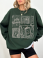 woman wearing dark green fully booked book lover sweatshirt with vintage reading illustrations relaxed oversized cozy outfit