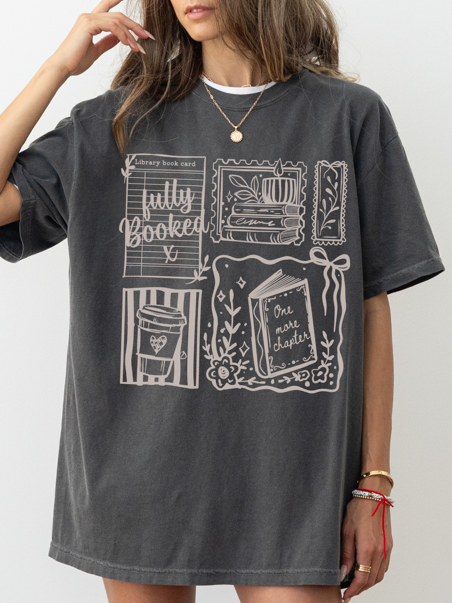 woman wearing pepper fully booked shirt with vintage style book lover illustrations including library card books and coffee cup