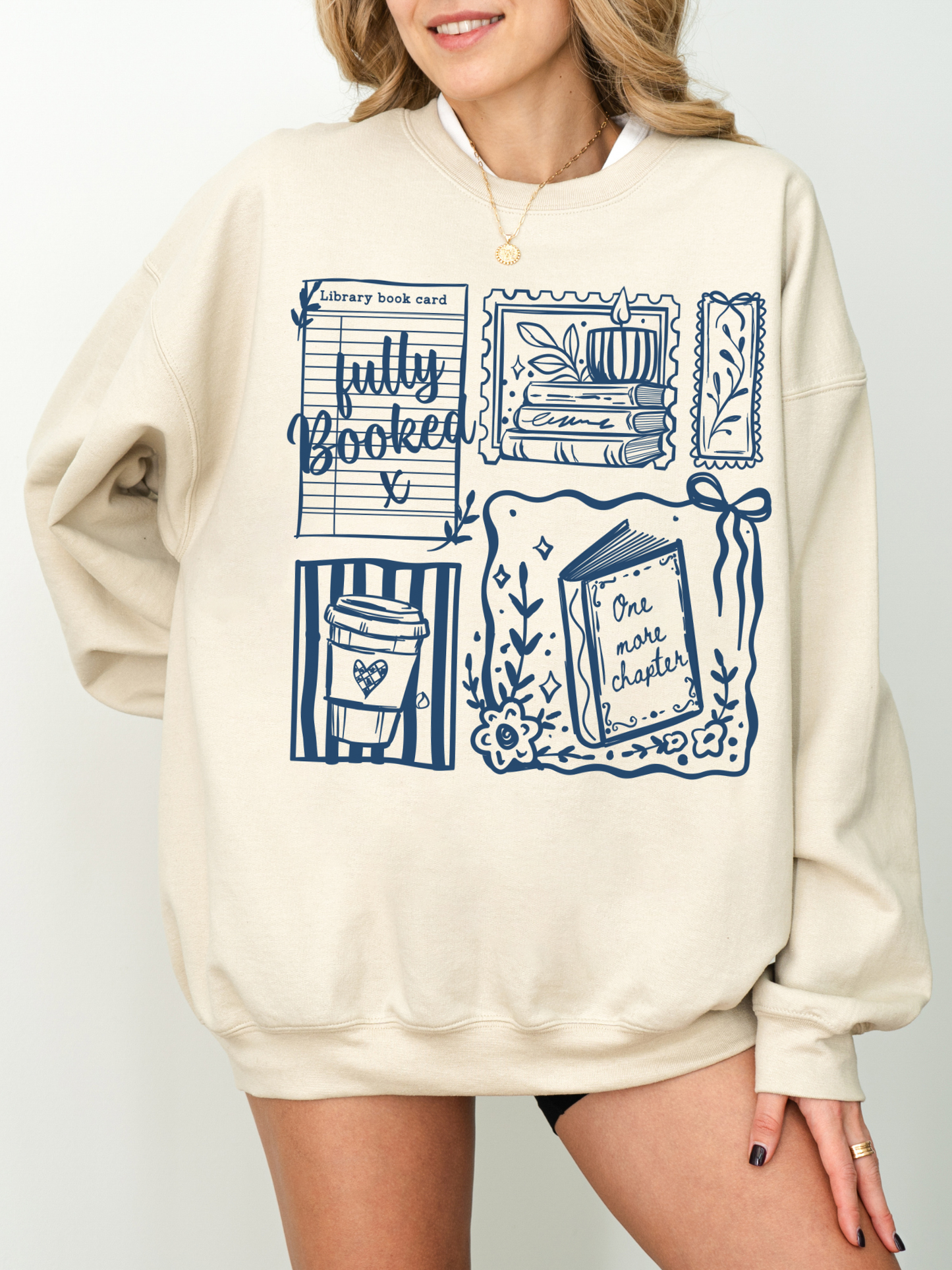 woman wearing sand fully booked book lover sweatshirt with vintage book themed illustrations oversized cozy style