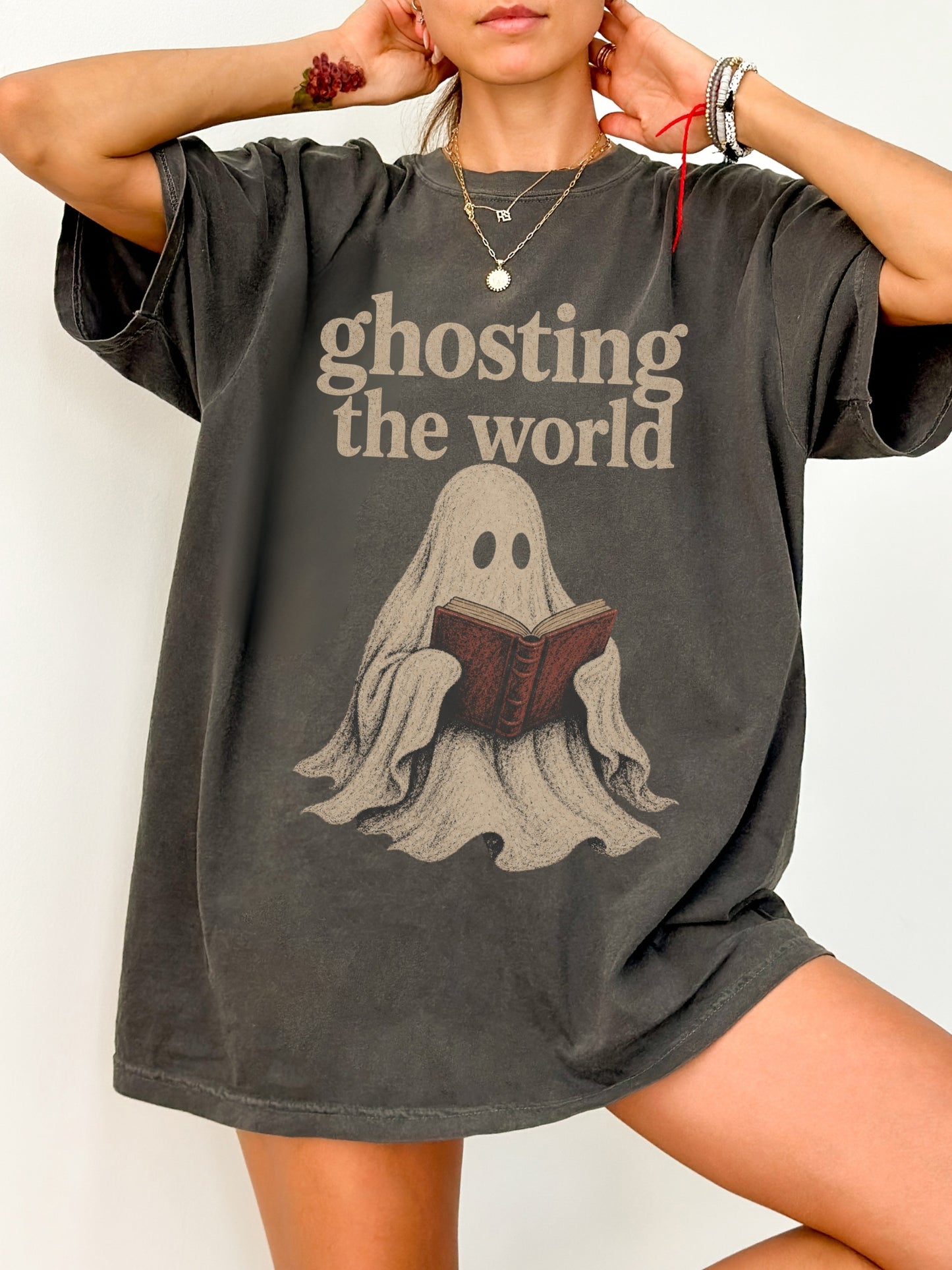 Model wearing a Pepper Comfort Colors bookish shirt featuring Ghosting the World text and a vintage ghost reading a book design