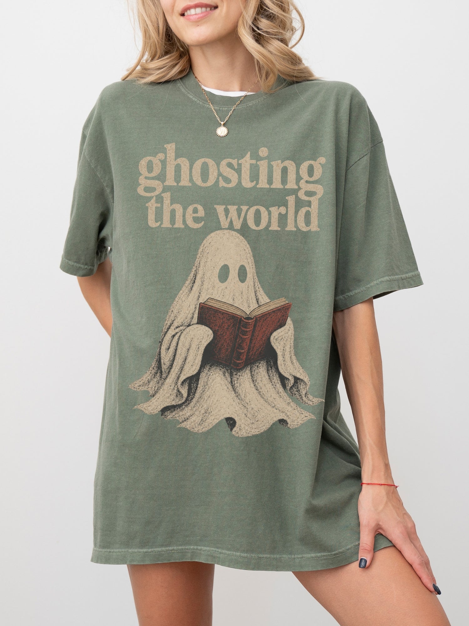 Model wearing a Moss Comfort Colors bookish shirt featuring Ghosting the World text and a vintage ghost reading a book illustration