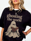 Model wearing a Black Comfort Colors bookish shirt featuring Ghosting the World text and a vintage ghost reading a red book design.