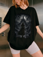 woman wearing a black gothic fantasy castle shirt with female warrior, dragons, and dark fantasy landscape graphic