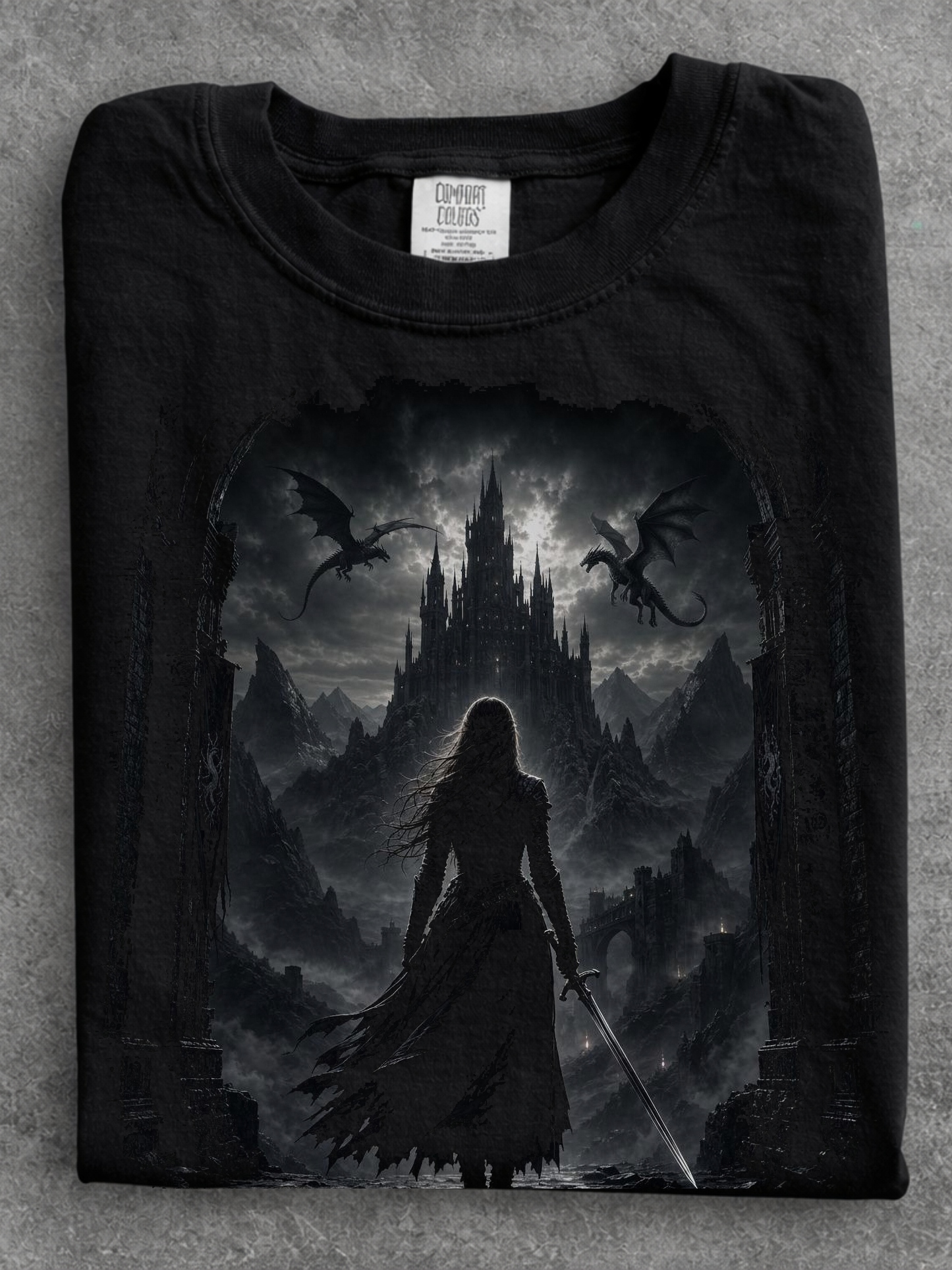 folded black comfort colors gothic fantasy castle shirt featuring female warrior, dragons, and medieval castle artwork