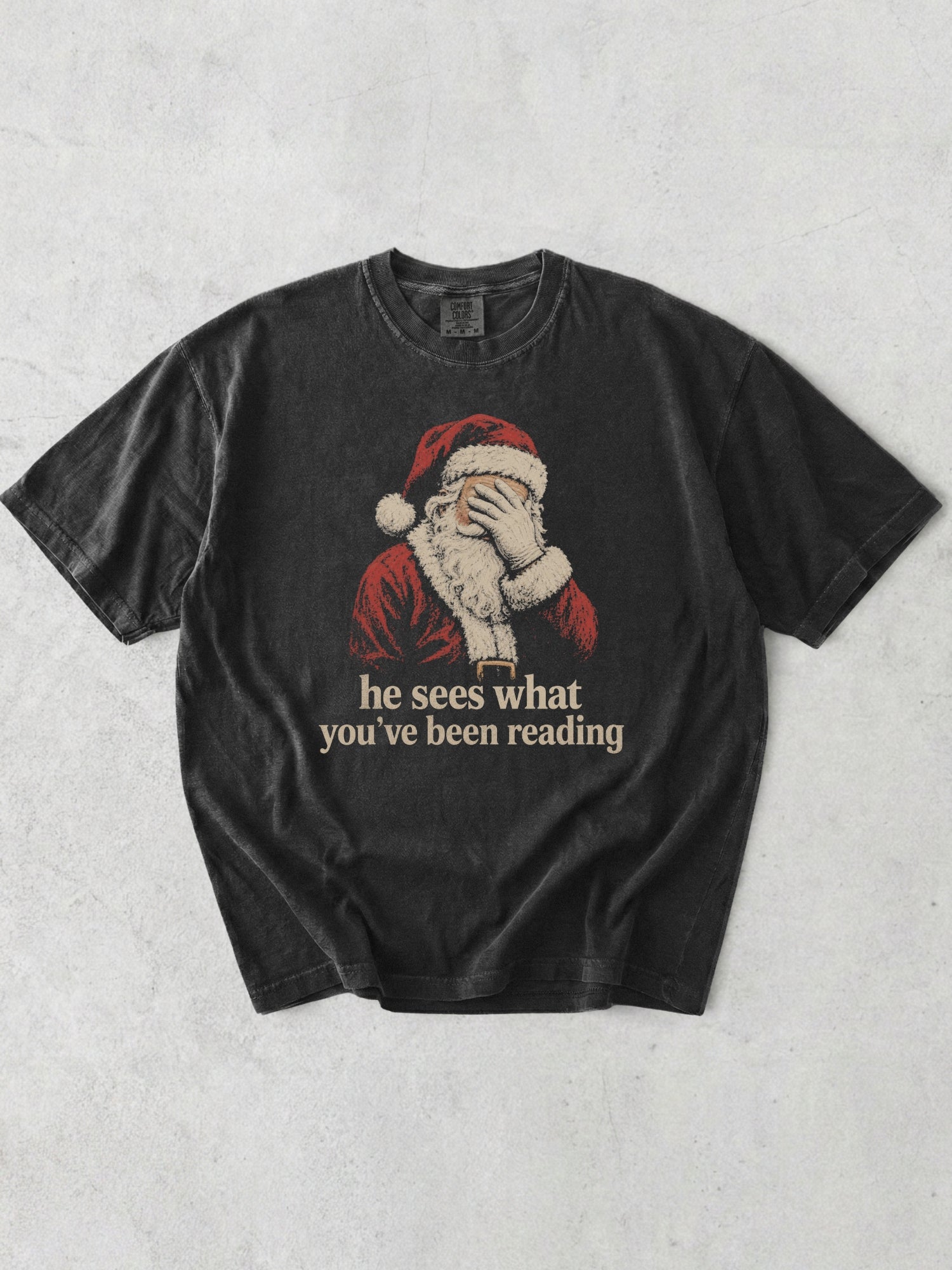 Graphite Comfort Colors shirt featuring vintage Santa covering his eyes with he sees what you’ve been reading text, a funny Christmas bookish shirt for readers and book lovers