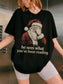 Black Comfort Colors shirt featuring vintage Santa covering his eyes with he sees what you’ve been reading text, a funny bookish Christmas shirt for readers and book lovers