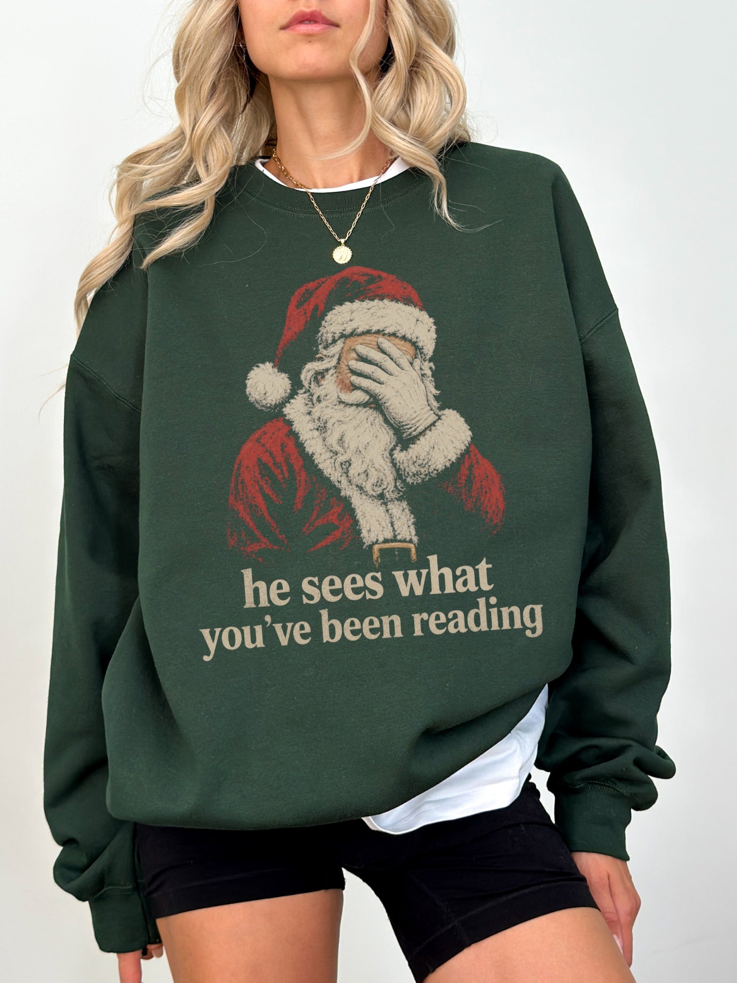 Forest Green Gildan sweatshirt featuring a vintage Santa design with he sees what you’ve been reading text, a funny bookish Christmas sweatshirt for readers