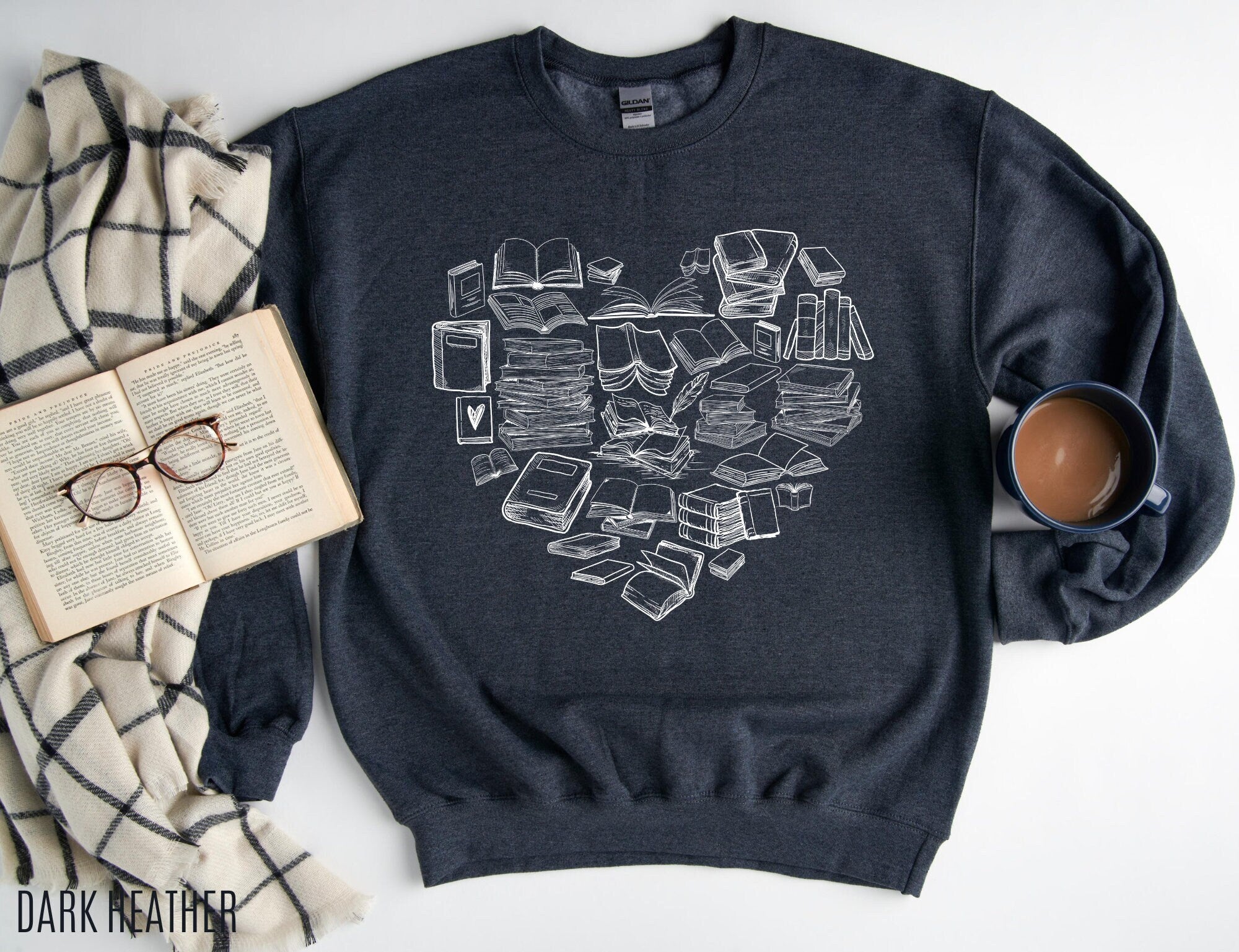 dark heather sweatshirt with white heart-shaped book design styled with coffee, blanket, and open book