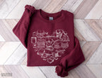 folded maroon sweatshirt with white book stacks arranged in a heart on wooden floor