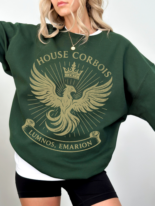 Woman wearing deep green sweatshirt with golden House Corbois crest, styled with white tee and shorts.