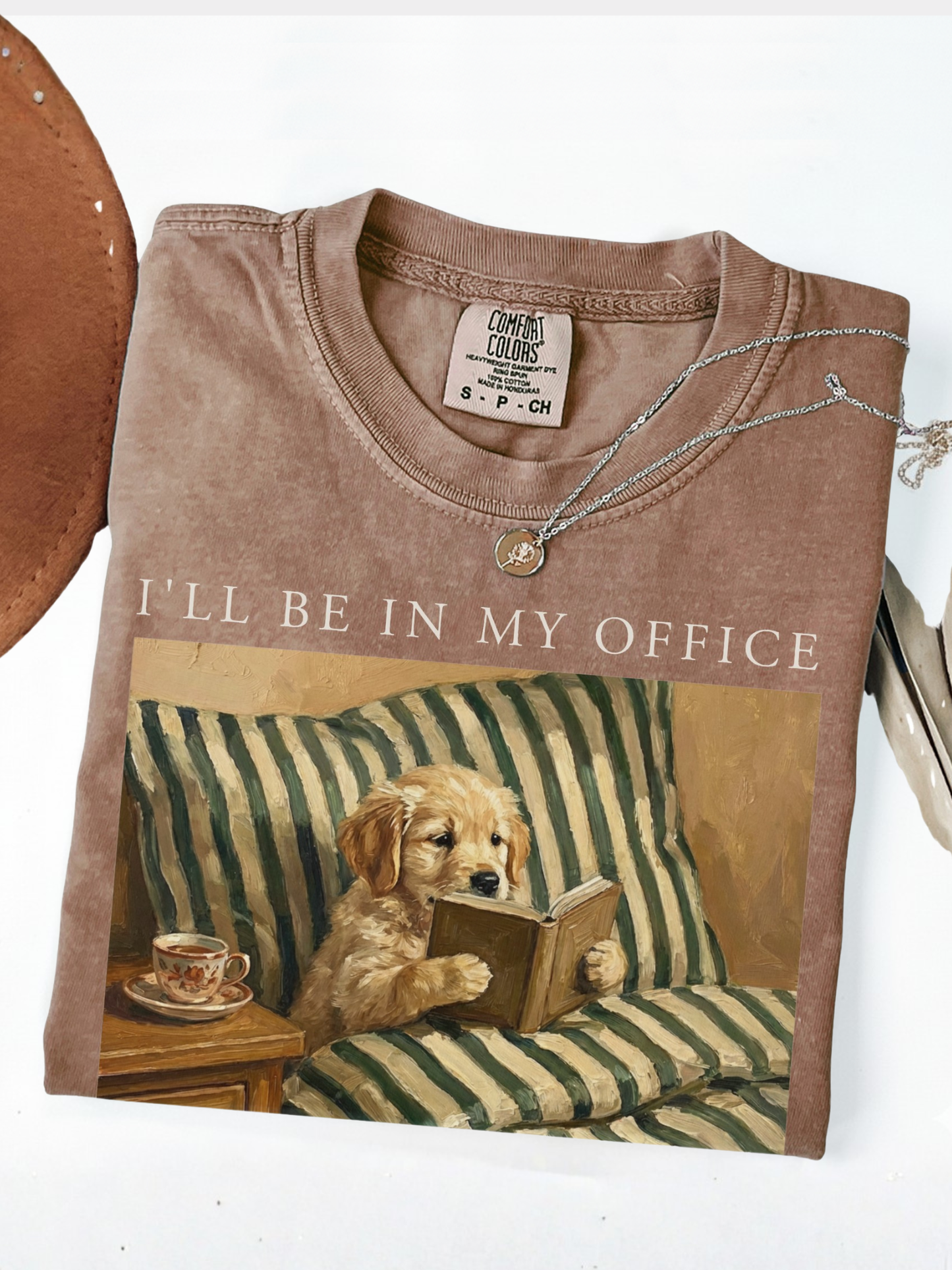 espresso comfort colors shirt with dog reading book design vintage painting style cozy reader aesthetic with coffee and neutral tones flatlay
