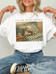 white oversized t shirt styled on model with dog reading book artwork and ill be in my office text cozy reader outfit aesthetic with jeans
