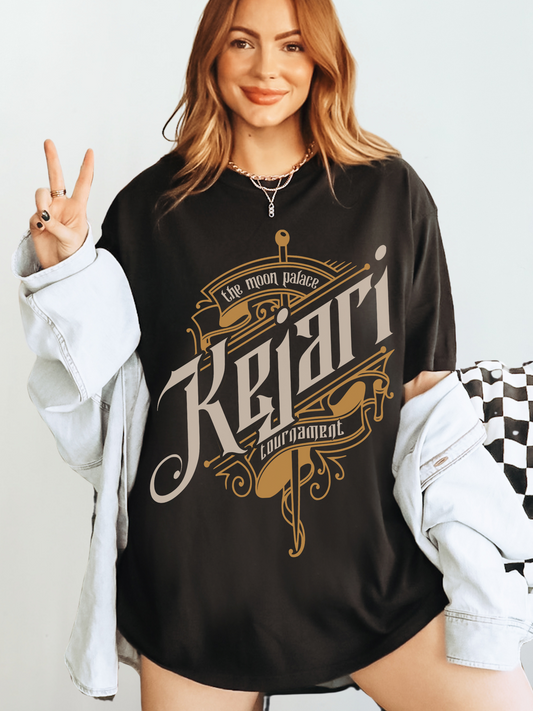 Woman wearing black Kejari Tournament T-shirt with gothic gold and cream sword design that reads “The Moon Palace Kejari Tournament,” official Crowns of Nyaxia merch from The Serpent and the Wings of Night by Carissa Broadbent.