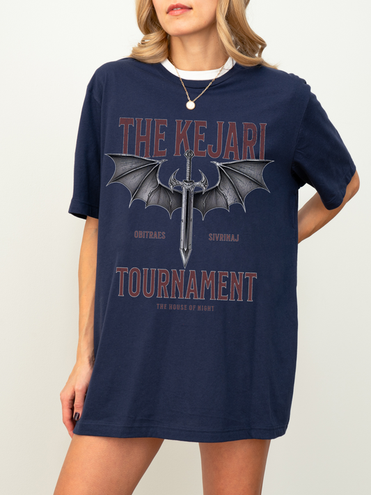 Front-facing shot of a woman wearing a navy blue Kejari Tournament fantasy book shirt with bold serif text, sword illustration with bat wings, and House of Night references for romantasy readers.