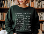 woman wearing forest green sweatshirt in library setting with white vintage library due date print