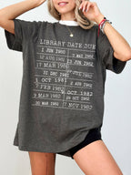 woman wearing a dark grey heather t-shirt with retro library due date graphic