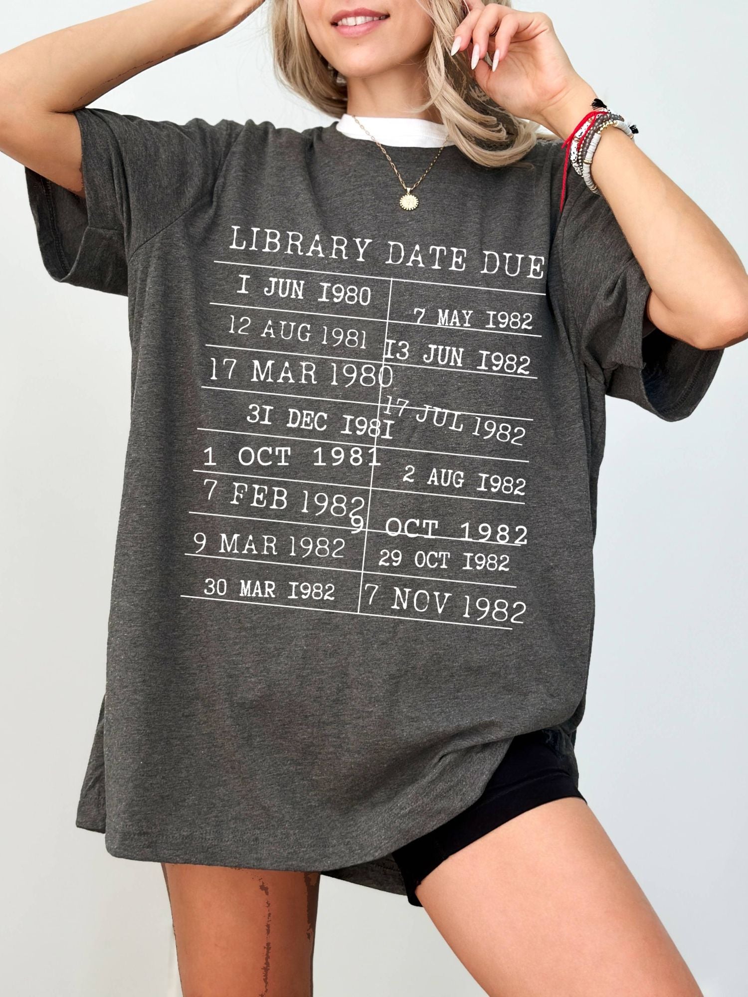 woman wearing a dark grey heather t-shirt with retro library due date graphic