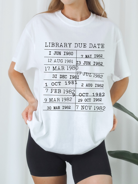 woman wearing a white t-shirt with bold black library due date print, bookish aesthetic