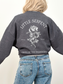 Woman in dark grey sweatshirt showing large back graphic of rose and snake with Little Serpent and Oraya of the Nightborn text, fantasy book apparel for fans of Carissa Broadbent