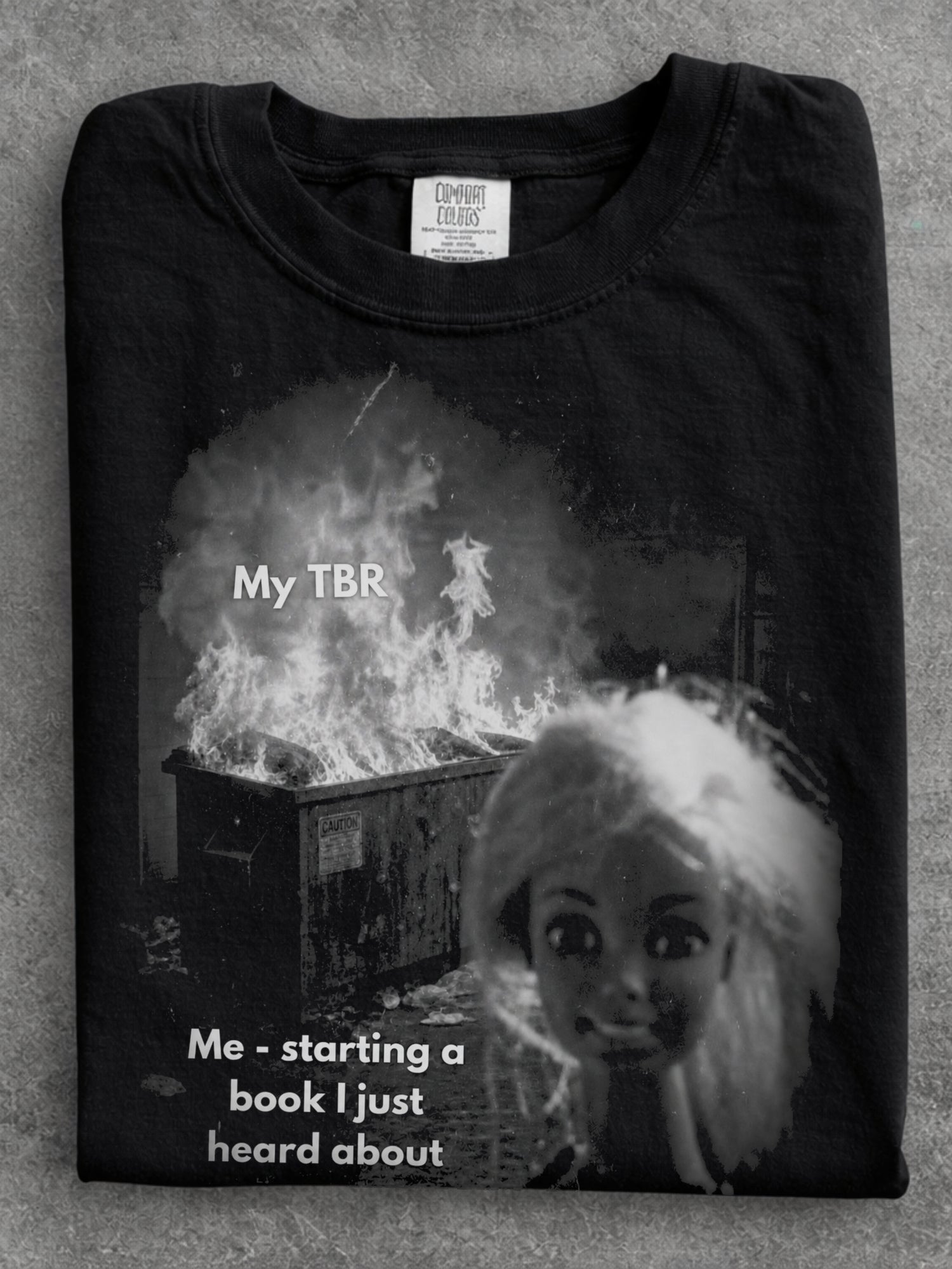 Black Comfort Colors shirt close up featuring a funny My TBR meme with a burning pile and Me starting a book I just heard about text, humorous reading shirt for bookworms and readers with an endless TBR