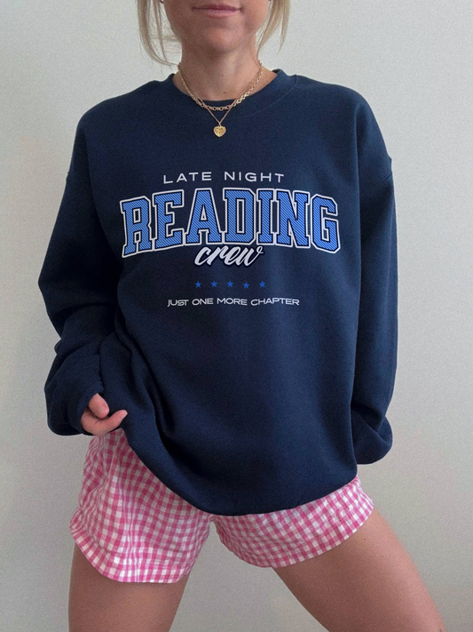 Woman wearing navy blue vintage “Late Night Reading Crew” sweatshirt with varsity lettering, styled with pink gingham shorts.