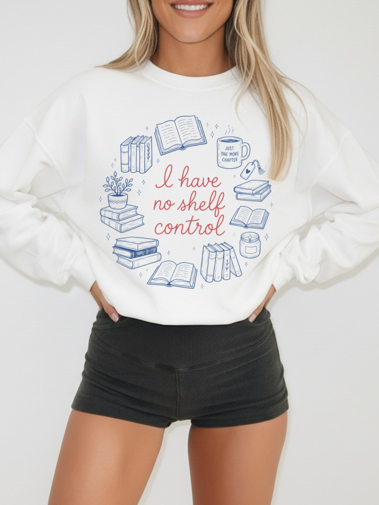 Woman wearing white sweatshirt with I have no shelf control text and blue book illustrations including stacks of books coffee mug and reading icons styled with black shorts