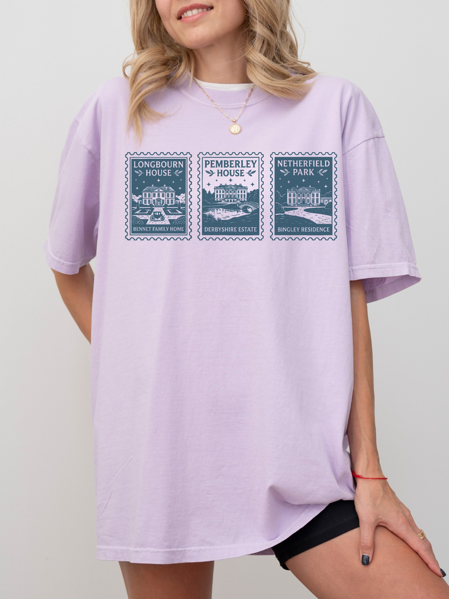 woman wearing oversized lilac t shirt with illustrated stamp design featuring Longbourn House Pemberley House and Netherfield Park inspired by Jane Austen