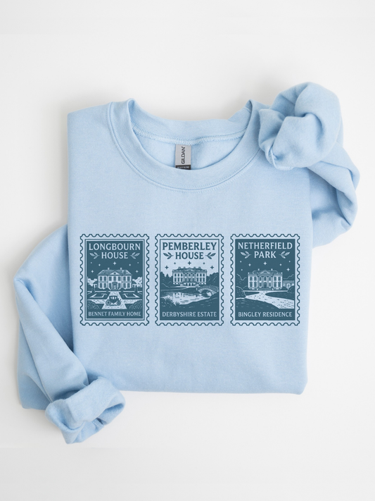 folded light blue sweatshirt with vintage stamp style design featuring Longbourn House Pemberley House and Netherfield Park inspired by Jane Austen