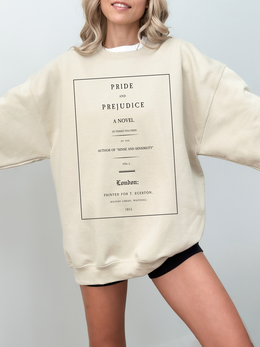 woman wearing sand-colored sweatshirt with classic Pride and Prejudice title page print in black