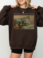 woman wearing oversized brown sweatshirt with probably reading trash raccoon reading book design warm cozy aesthetic book lover apparel