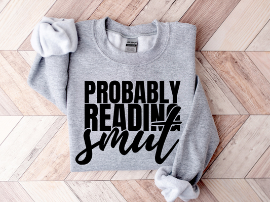 folded sport grey Probably Reading Smut sweatshirt with bold black text on wood floor