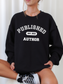 woman sitting cross-legged wearing black sweatshirt that says published author est 2012