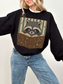 woman wearing black Gildan raccoon reading book sweatshirt with vintage bookish raccoon wearing glasses and fantasy book graphic
