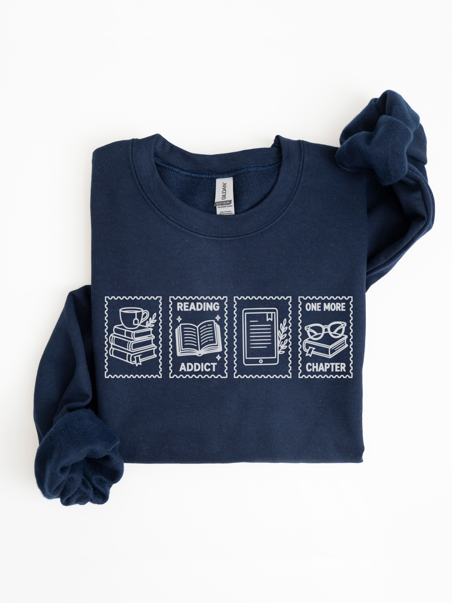 folded navy blue sweatshirt featuring reading addict one more chapter postage stamp design with book stack coffee mug open book e reader and reading glasses artwork for readers