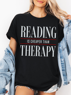 black comfort colors reading is cheaper than therapy shirt with minimalist typography design styled with denim jacket and shorts