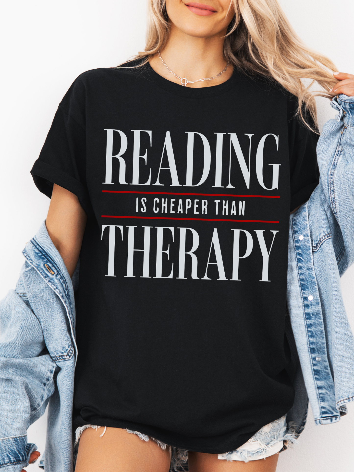 black comfort colors reading is cheaper than therapy shirt with minimalist typography design styled with denim jacket and shorts