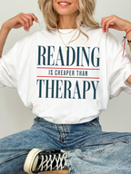 white comfort colors reading is cheaper than therapy shirt with clean typography design for readers and book lovers