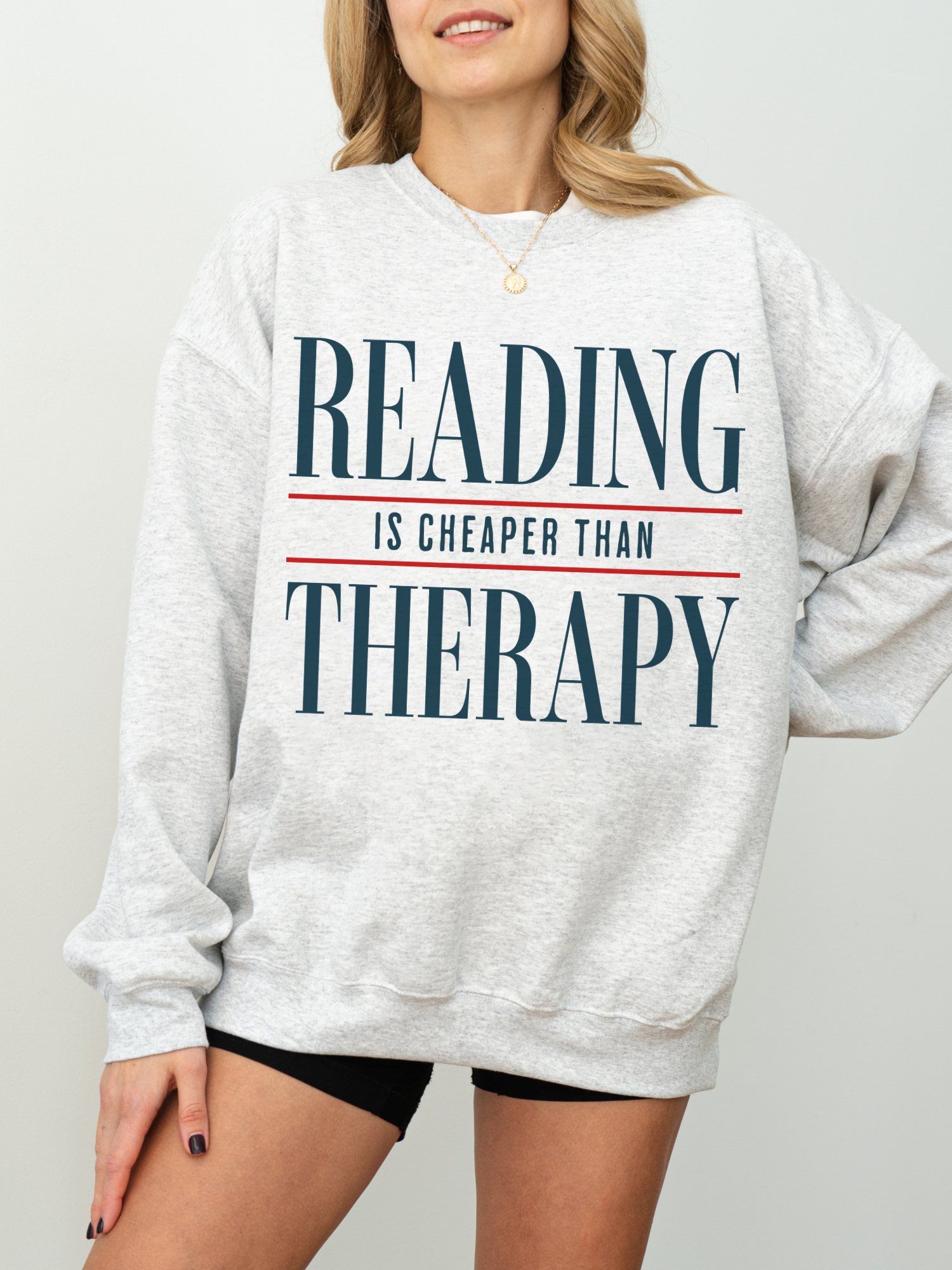 ash gray reading is cheaper than therapy sweatshirt for book lovers featuring minimalist typography design on cozy oversized crewneck