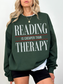 forest green reading is cheaper than therapy sweatshirt for readers and bookworms with large typography graphic design