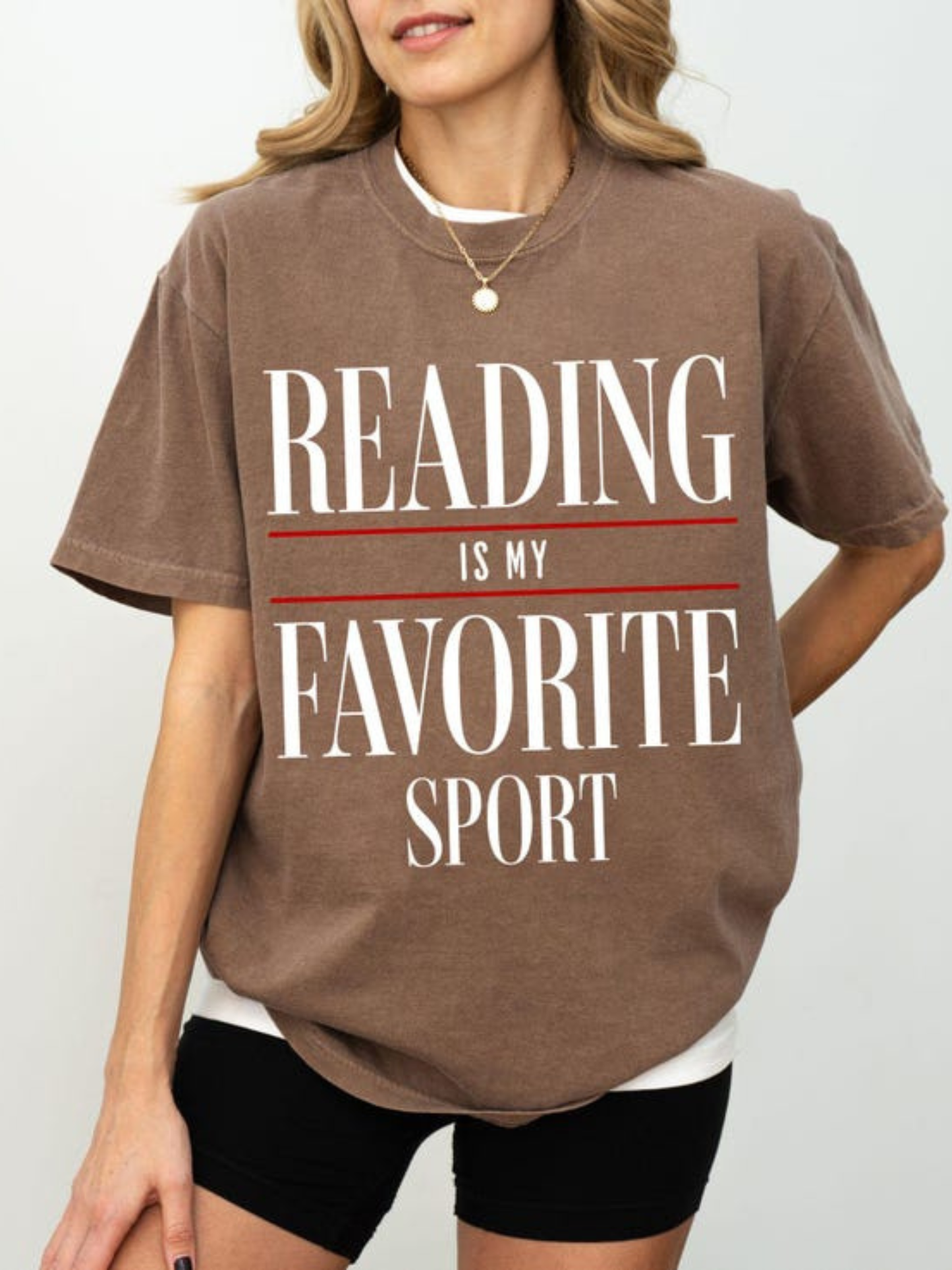 woman wearing espresso reading is my favorite sport comfort colors t shirt with relaxed fit styled with black shorts minimalist outfit