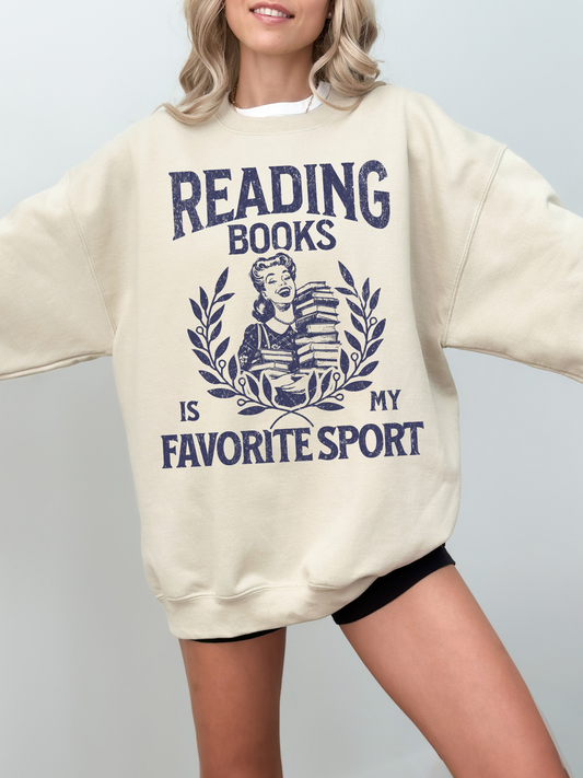 woman wearing an oversized sand-colored sweatshirt that says reading books is my favorite sport in vintage font