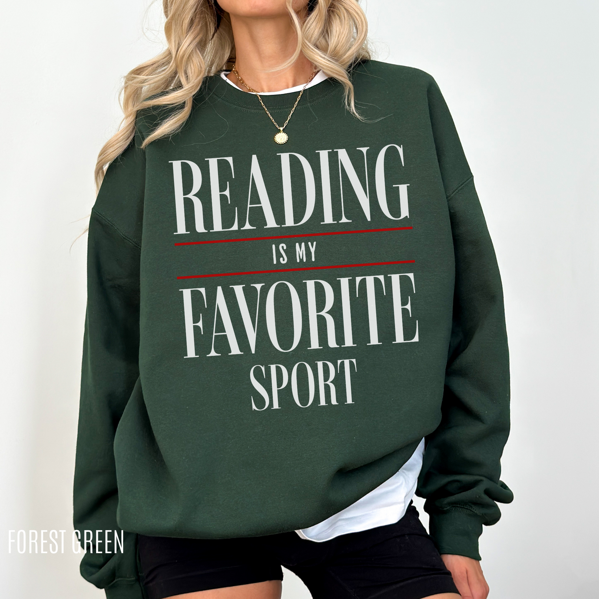 woman standing in forest green sweatshirt with large text reading is my favorite sport in white and red