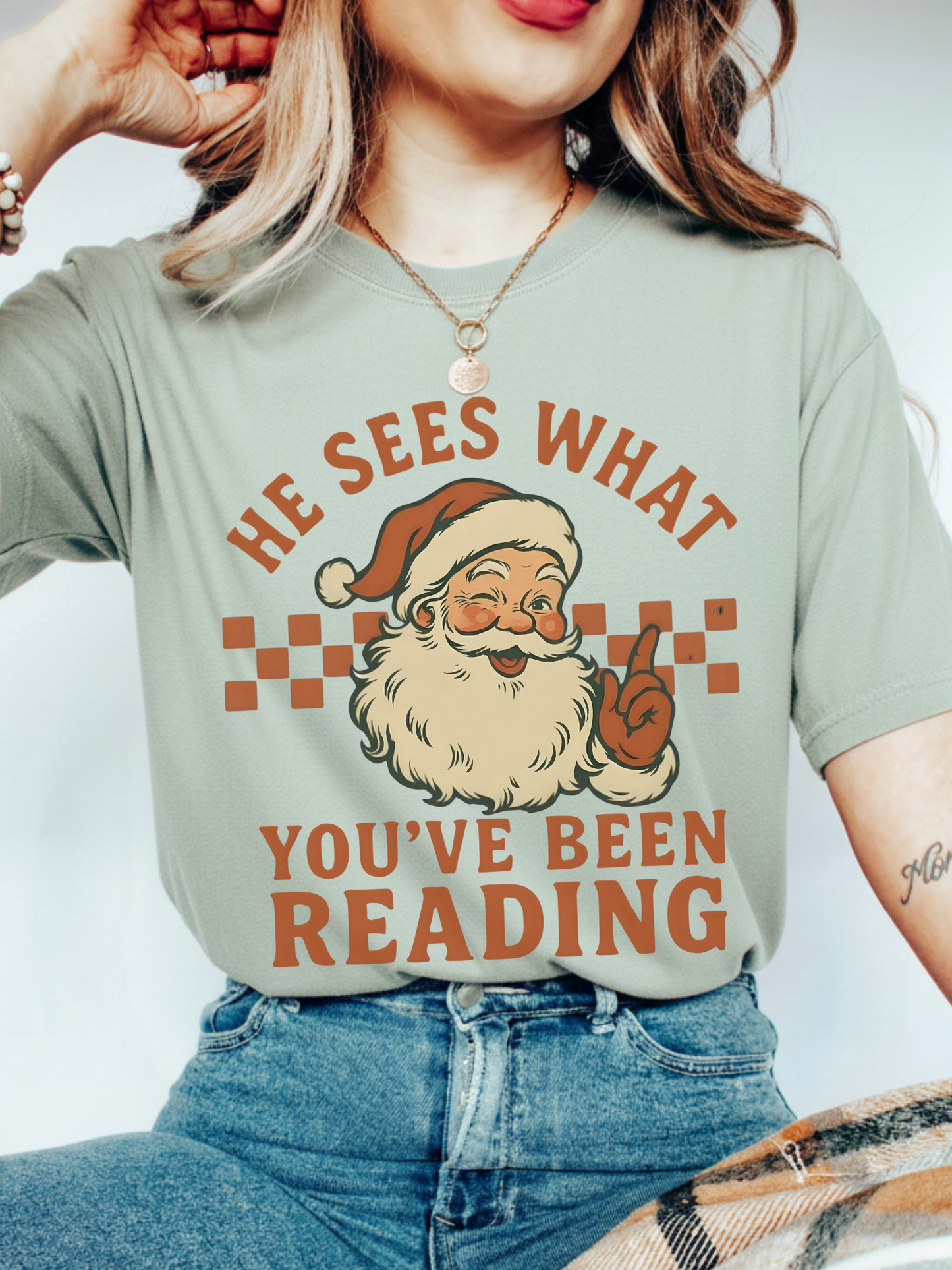 Close-up of woman wearing bay green Santa reader shirt with retro style design and red lipstick