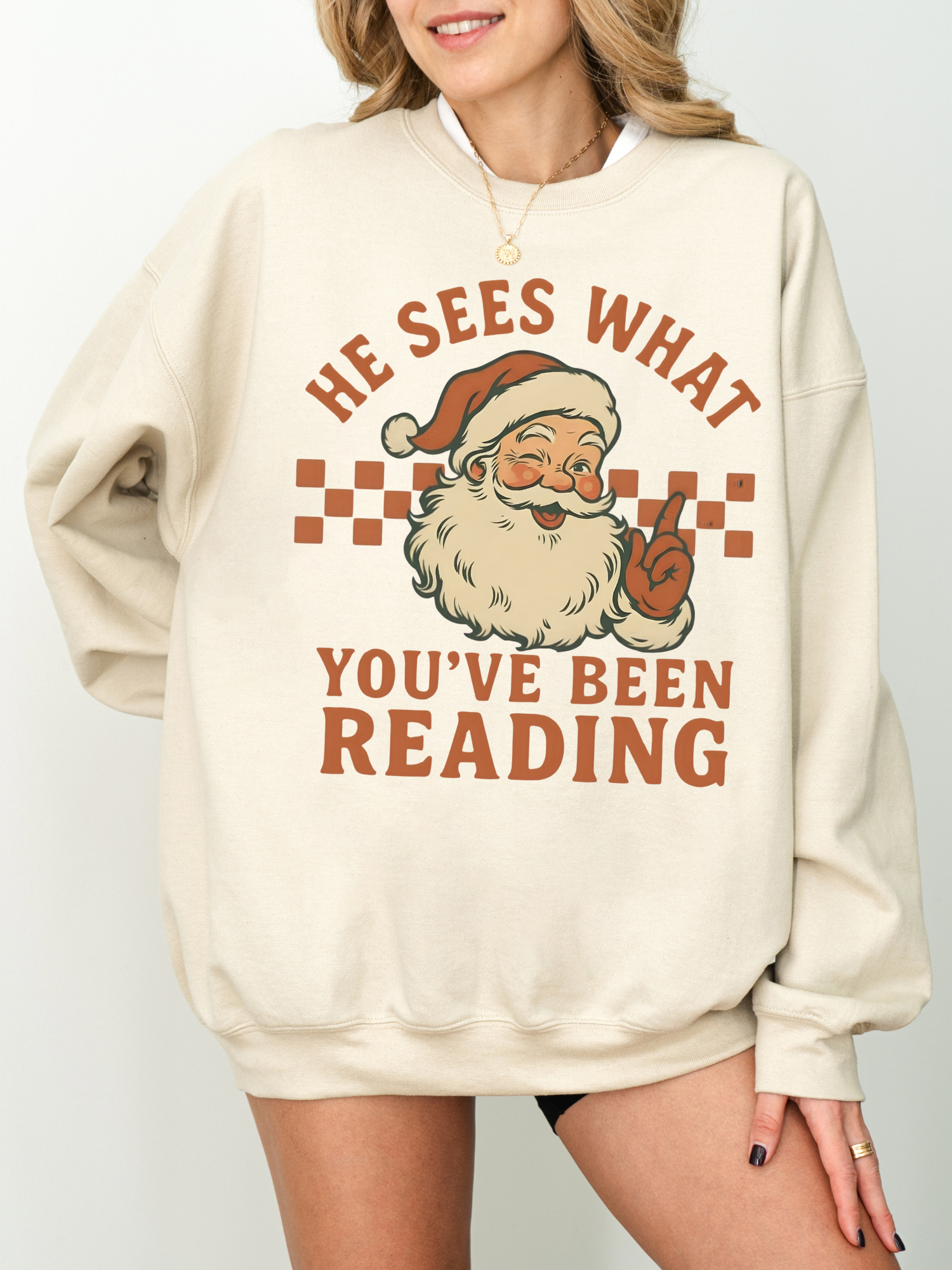 girl wearing sand-colored sweatshirt with retro Santa and cheeky reading quote