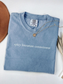 folded denim blue Comfort Colors tee with spicy literature connoisseur phrase and cozy neutral props