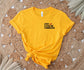 bright yellow t-shirt with black text and red chili pepper that says spicy literature connoisseur on woven rug background