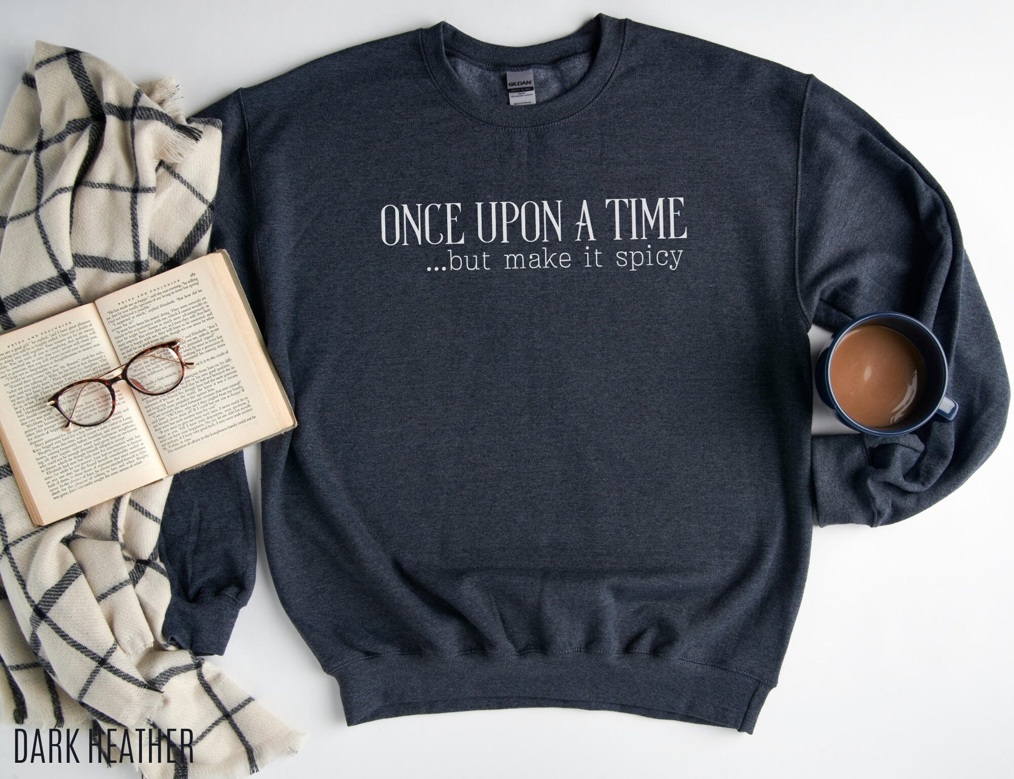 dark heather sweatshirt laid out with mug, book, and plaid blanket, text reads once upon a time but make it spicy