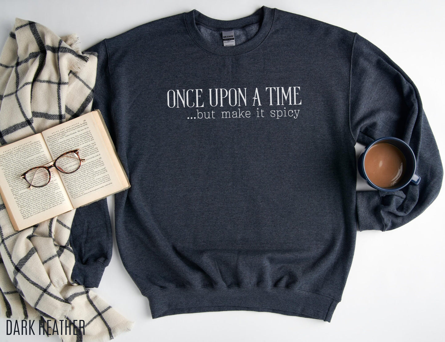 dark heather sweatshirt laid out with mug, book, and plaid blanket, text reads once upon a time but make it spicy