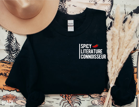 flat lay of black Spicy Literature Connoisseur sweatshirt with pepper icon, styled with hat and pampas grass